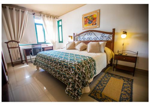 a bedroom with a bed and a desk and a window at HOTEL BOUTIQUE EL RANCHO OLIVO in Villamontes