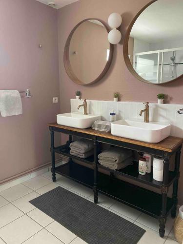 une salle de bain avec deux lavabos et un grand miroir dans l'établissement Les Gites Du Moulin Du Port, à Saint-Georges-sur-Cher
