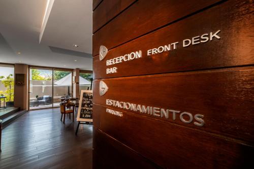 a wooden wall with the sign for a room from the front of a restaurant at Hotel Los Españoles Plus in Santiago