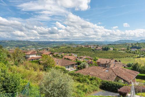 ein Dorf auf einem Hügel mit Häusern und Weinbergen in der Unterkunft Basumse Holiday Apartments, Langhe in Roddi