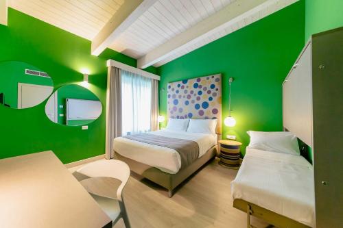 a green bedroom with a bed and a tv at Diamante MHotel in Collegno