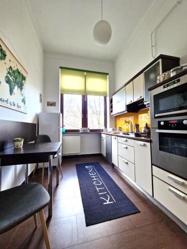 a kitchen with a table and a kitchen rug on the floor at Deák Apartman in Sopron