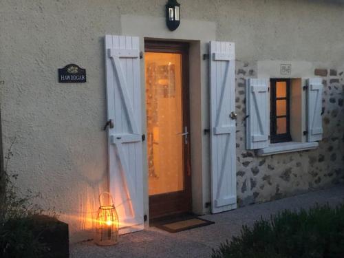 a door with a light in front of a building at Le gîte de Lou - Piscine privative et massages Bien-être in Mazerolles
