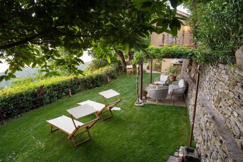 a garden with two tables and chairs on the grass at La Casa sul Forte in Seravezza