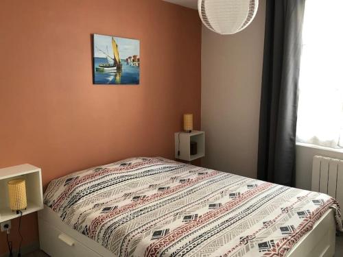 une chambre avec un lit avec une couette dessus dans l'établissement Apt 4 personnes wifi, à Hyères