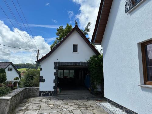 a white house with a doorway in a yard at Schöne Ferienwohnung im Landhaus in Stadtlengsfeld