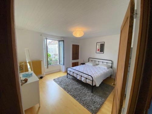 une chambre avec un lit au milieu d'une pièce dans l'établissement Maison normande typique a 150m mer 10 personnes, à Saint-Aubin-sur-Mer