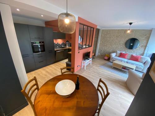 une table à manger avec des chaises et un salon dans l'établissement Maison normande typique a 150m mer 10 personnes, à Saint-Aubin-sur-Mer