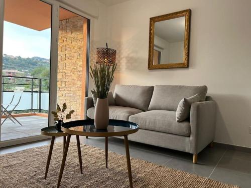 a living room with a couch and a table with a mirror at Charmant appartement a Bormes les Mimosas in Bormes-les-Mimosas