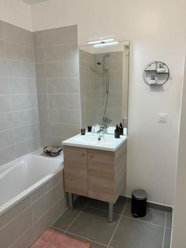 a bathroom with a sink and a tub and a mirror at Charmant appartement a Bormes les Mimosas in Bormes-les-Mimosas