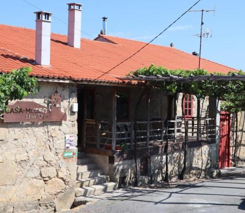a stone building with a red roof and a balcony at Casa-Museo Genia Trigo in Sober