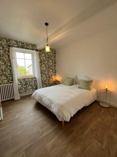 une chambre avec un grand lit blanc avec une fenêtre dans l'établissement Marguerite, à Saint-Haon-le-Châtel