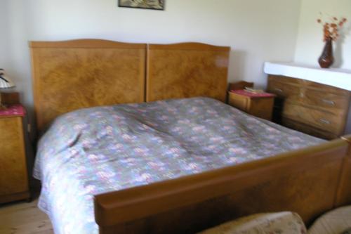 a bedroom with a wooden bed and a dresser at Faluszéli Vendégház - Boncz Porta in Nagyrákos