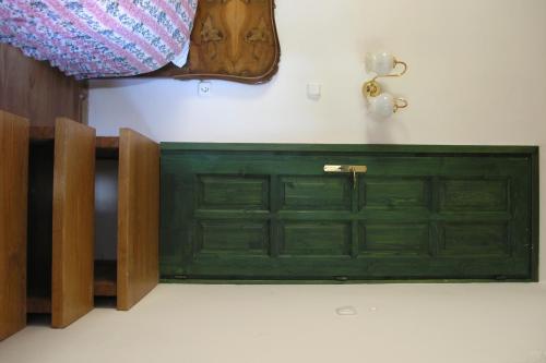 a green door in the corner of a room at Faluszéli Vendégház - Boncz Porta in Nagyrákos