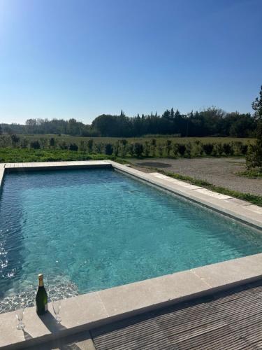- une bouteille de vin près de la piscine dans l'établissement Charmante maison Provençale avec grand jardin, à LʼIsle-sur-la-Sorgue
