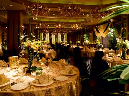 a dining room with many tables with plates and flowers at Koriyama View Hotel in Koriyama
