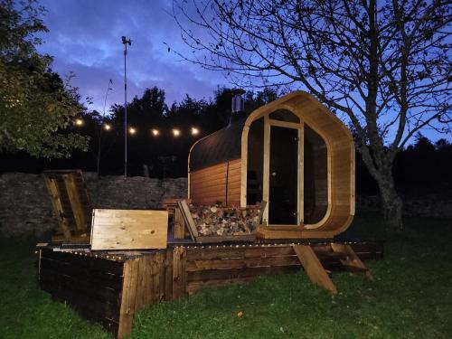 a large wooden dog house sitting in the grass at Gîte BARD des OURS in Saint-Martin-en-Vercors