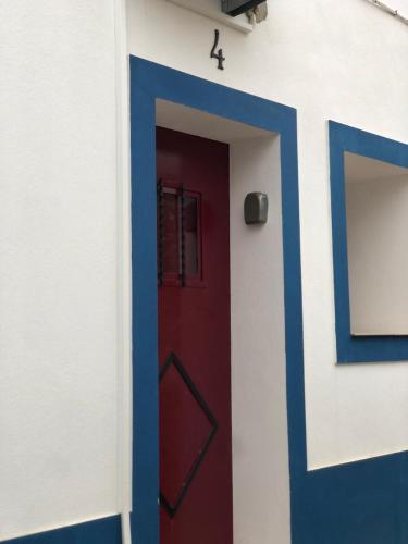 a red and blue door in a white building at Recanto da Aldeia in Monsaraz