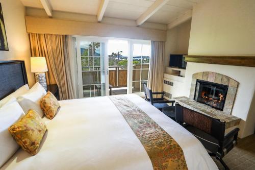 a hotel room with a bed and a fireplace at Tradewinds Carmel in Carmel