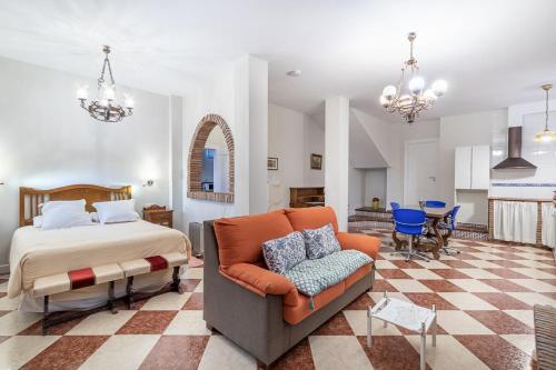 a bedroom with a bed and a couch at Senderos de la Alhambra in La Zubia