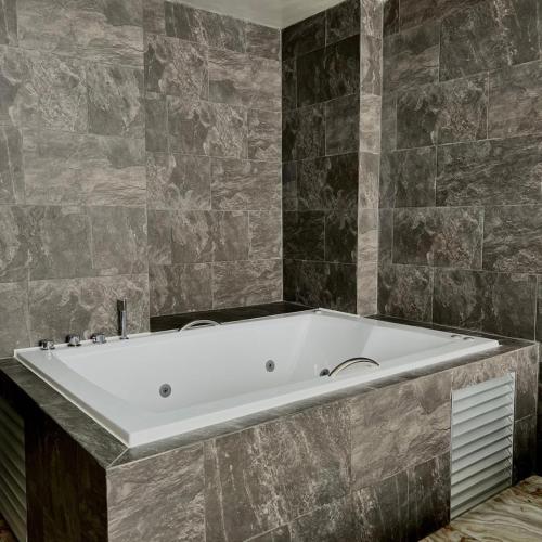 a large white bath tub in a bathroom at Hotel Villa Nueva Comfort in Medellín