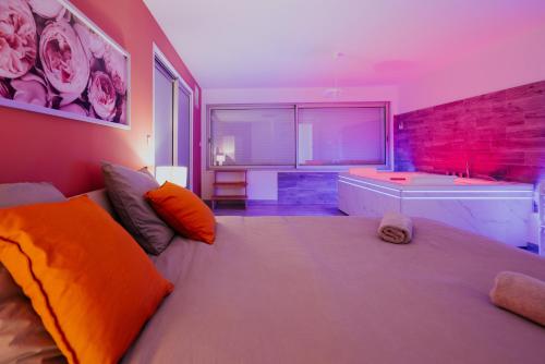 a bedroom with a large bed and a bath tub at AppartSpa59 - Suite Tentation - Balnéo, Sauna - Secret Room en option supplémentaire in Valenciennes