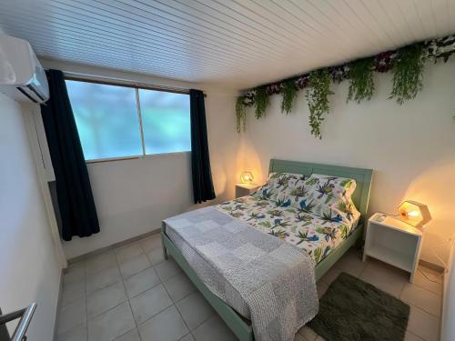 a bedroom with a bed and a window at Choupchoup Jeux de Société 972 in Quartier Morne la Valeur