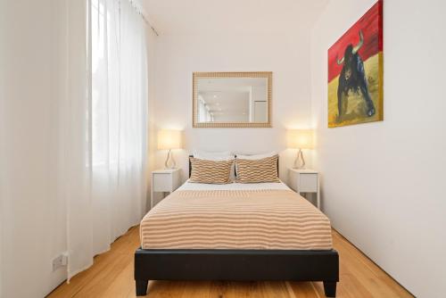 a bedroom with a bed with two lamps on both sides at Oxford Circus Designer Apartment in London