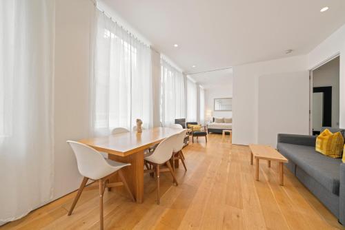 a living room with a table and chairs and a couch at Oxford Circus Designer Apartment in London