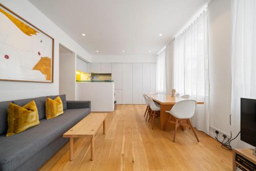 a living room with a couch and a table at Oxford Circus Designer Apartment in London