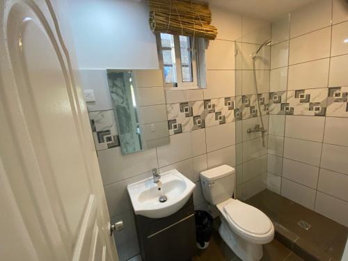 un baño con inodoro y lavabo en Big Blue Apartments, en Cabarete