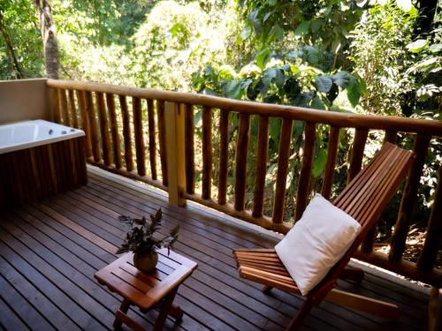 a wooden deck with a chair and a bath tub at La Aldea De La Selva Lodge in Puerto Iguazú