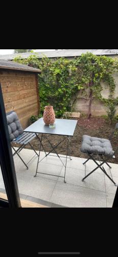 une table et deux chaises sur une terrasse dans l'établissement Appartement paisible, à Argenteuil
