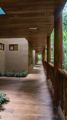 a wooden walkway leading to a building with a wooden ceiling at La Aldea De La Selva Lodge in Puerto Iguazú