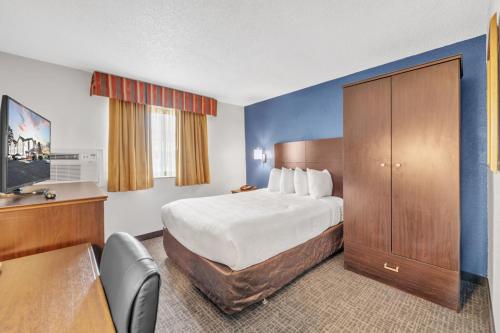 a hotel room with a bed and a desk at City Centre Inn at Newport News in Newport News