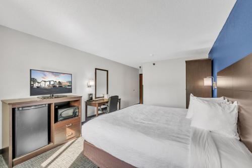 a hotel room with a bed and a flat screen tv at City Centre Inn at Newport News in Newport News