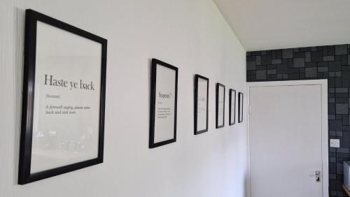 a row of framed pictures hanging on a wall at 175 On Clyde - Spacious & Cosy Cedar Wood Bungalow in Helensburgh