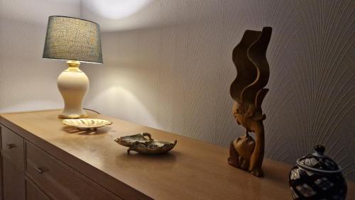 a table with a lamp and other items on it at 175 On Clyde - Spacious & Cosy Cedar Wood Bungalow in Helensburgh