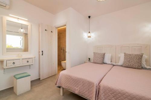 a bedroom with a large bed and a bathroom at Villa Vardiola by Villa Plus in Skinária