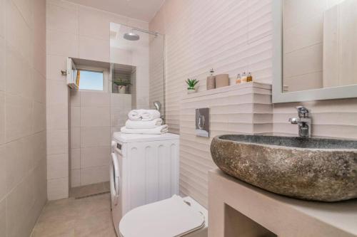 a bathroom with a sink and a toilet at Villa Vardiola by Villa Plus in Skinária