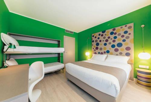 a bedroom with green walls and a bed and bunk beds at Diamante MHotel in Collegno