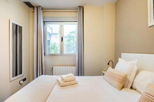 a bedroom with a white bed with a window at Moderno apartamento con vistas al mar en Valencia in Valencia