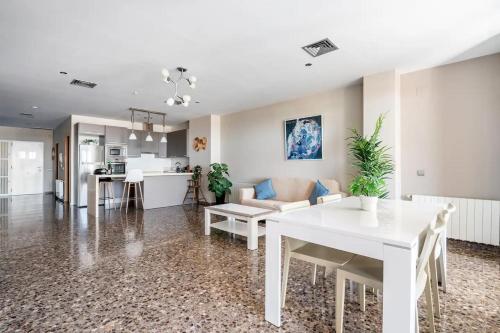 a living room with a white table and a kitchen at Moderno apartamento con vistas al mar en Valencia in Valencia