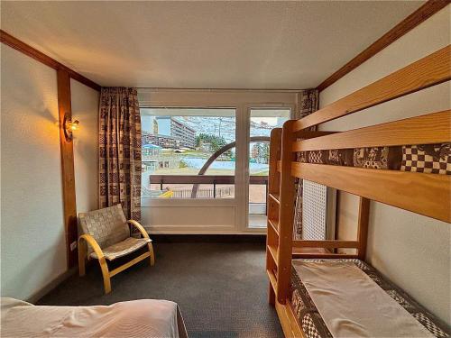 une chambre avec deux lits superposés et une fenêtre dans l'établissement Appartement rénové pour 4 pers au pied des pistes - La Croisette - FR-1-452-196, aux Menuires