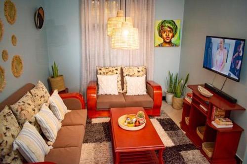 ein Wohnzimmer mit Sofa und Tisch in der Unterkunft ILBORU HAVEN HOMEs in Arusha