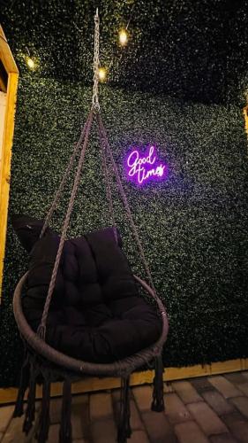 a hanging chair with a neon sign on a wall at Modern 3BR Near FSU - 15 Min to Wachusett in Fitchburg