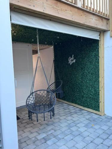 a swinging bench in a garage with a green wall at Modern 3BR Near FSU - 15 Min to Wachusett in Fitchburg