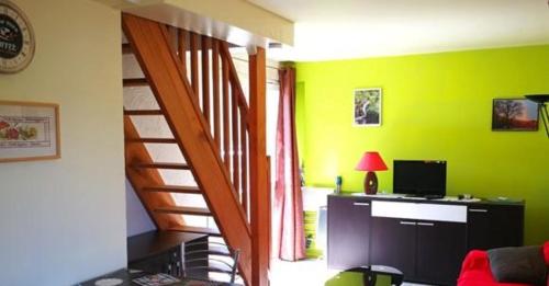 un salon aux murs verts et un bureau avec un ordinateur dans l'établissement La Maison au bord du lac de Vassiviere, à Soumeix