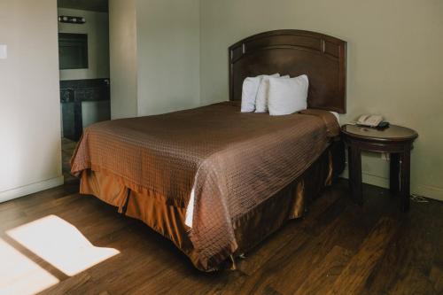 a hotel room with a bed and a telephone at La Hacienda Motel in Seattle