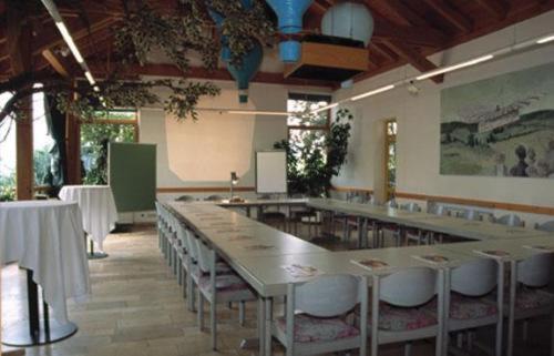 a large dining room with tables and white chairs at Hotel Bergwirt in Herrieden